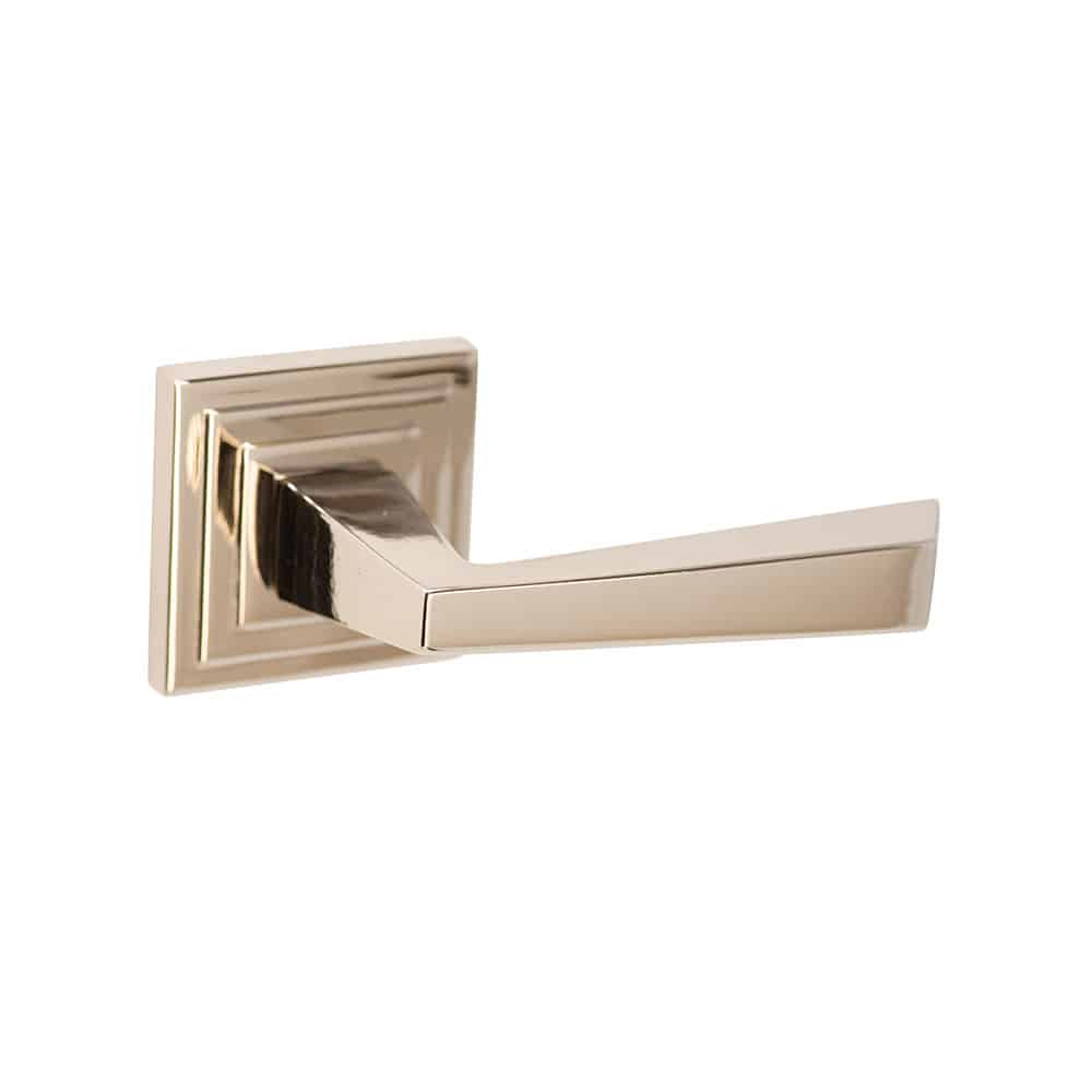A modern gold accent brass door handle with a square base